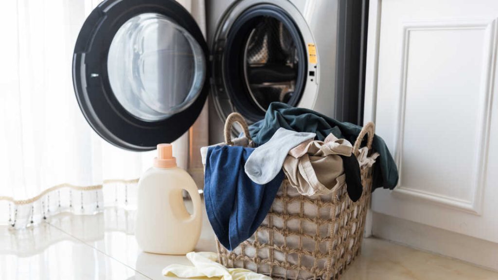 Basket with laundry and washing machine